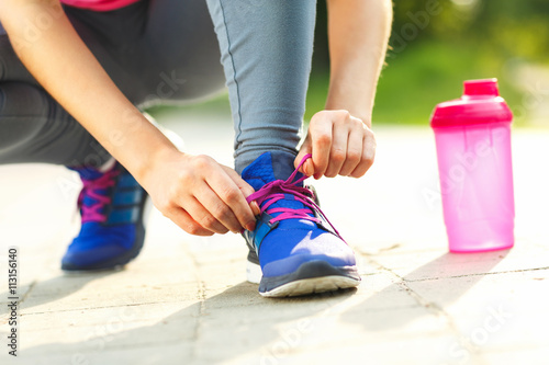 Running shoes - woman tying shoe laces