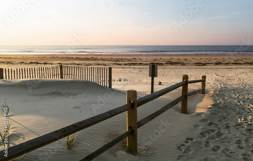 Sand dunes, a wooden fence on a background of blue ocean Ocean city NJ