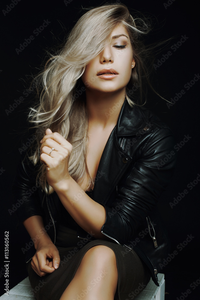 Naklejka premium very beautiful girl sitting on a chair in the studio in a leathe