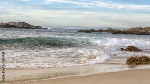 blue ocean waves hitting a sandy beach
