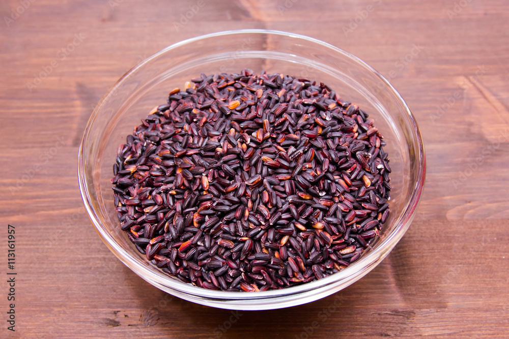 Bowl with black rice on a wooden table Bowl with black rice on a wooden table