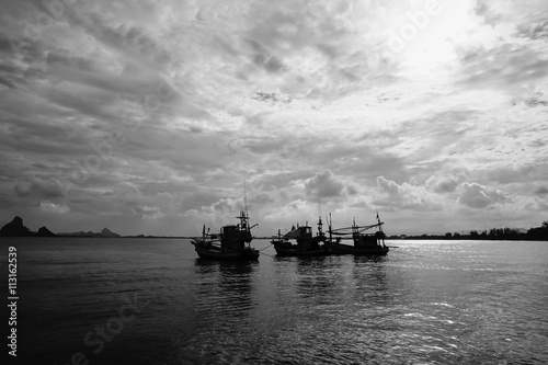 silhouette of three traditional boat laying on the sea with peace wave, black and white picture style