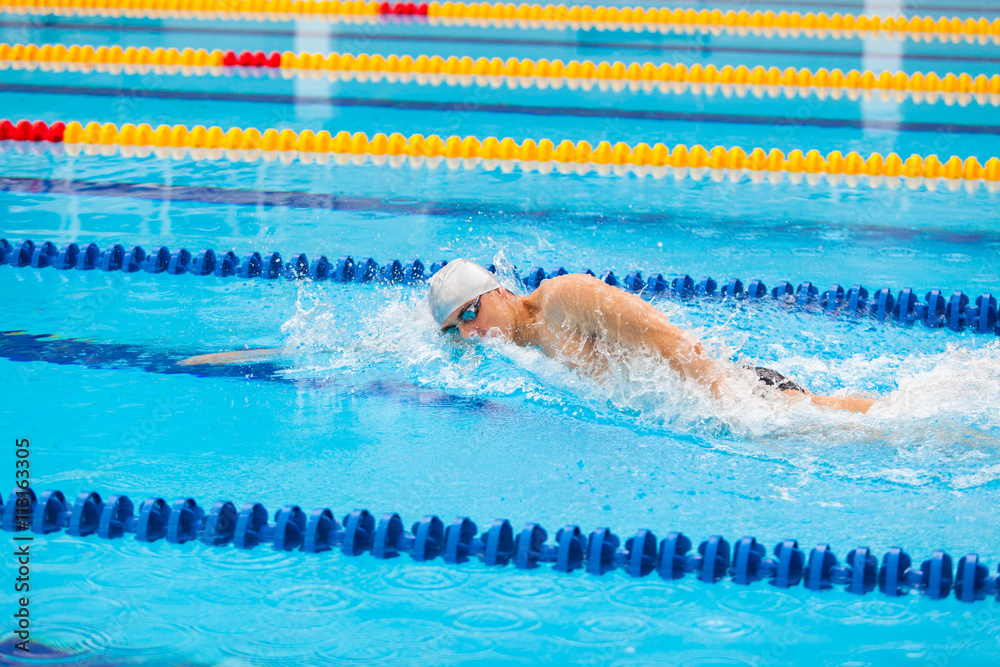 Man swimmer swimming crawl in blue water.