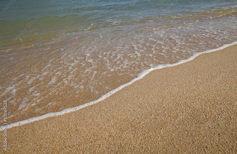 Obraz premium close up soft wave on a sand beach, sea foam, splash of the sea