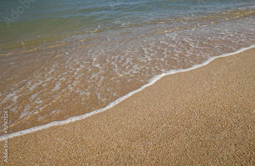 close up soft wave on a sand beach, sea foam, splash of the sea