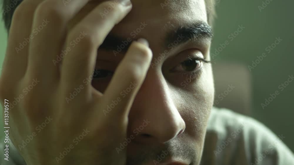 Depressed young adult closeup. People with depressed mood can feel sad, anxious, empty, hopeless, helpless, worthless, guilty, irritable or restless.