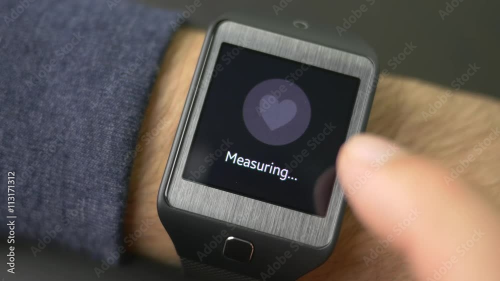 Man checking his heart beat on a wearable smartwatch computer device. Wearable technology is a growing trend. 