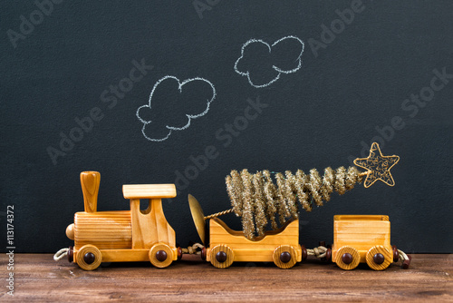 Christmas concept, old wooden toy train with Christmas tree, steam on the chalkboard background