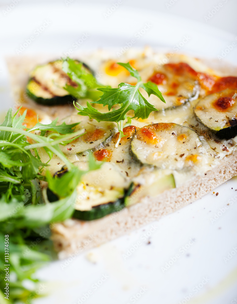 Whole Grain pizza with vegetables and fresh salad on a white plate Selective focus Whole Grain pizza with vegetables and fresh salad on a white plate Selective focus