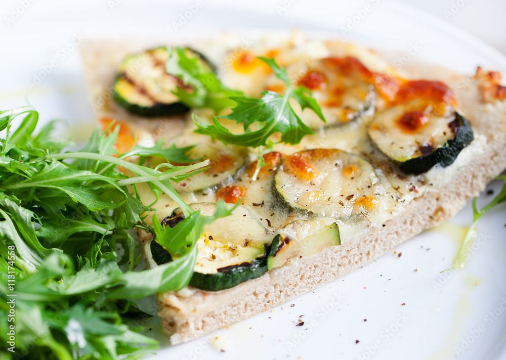 Whole Grain pizza with vegetables and fresh salad on a white plate Selective focus Whole Grain pizza with vegetables and fresh salad on a white plate Selective focus