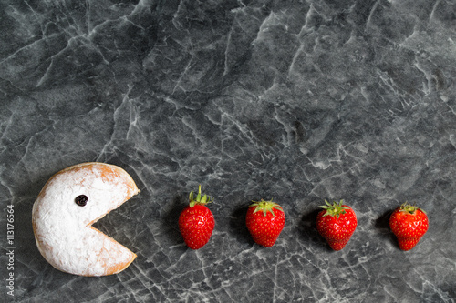 Bild auf Leinwand Powdered donut eating fresh red strawberries