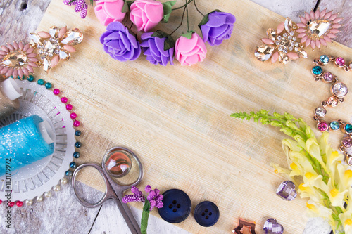 Plastic berries, flowers, beads and instruments on white wood background