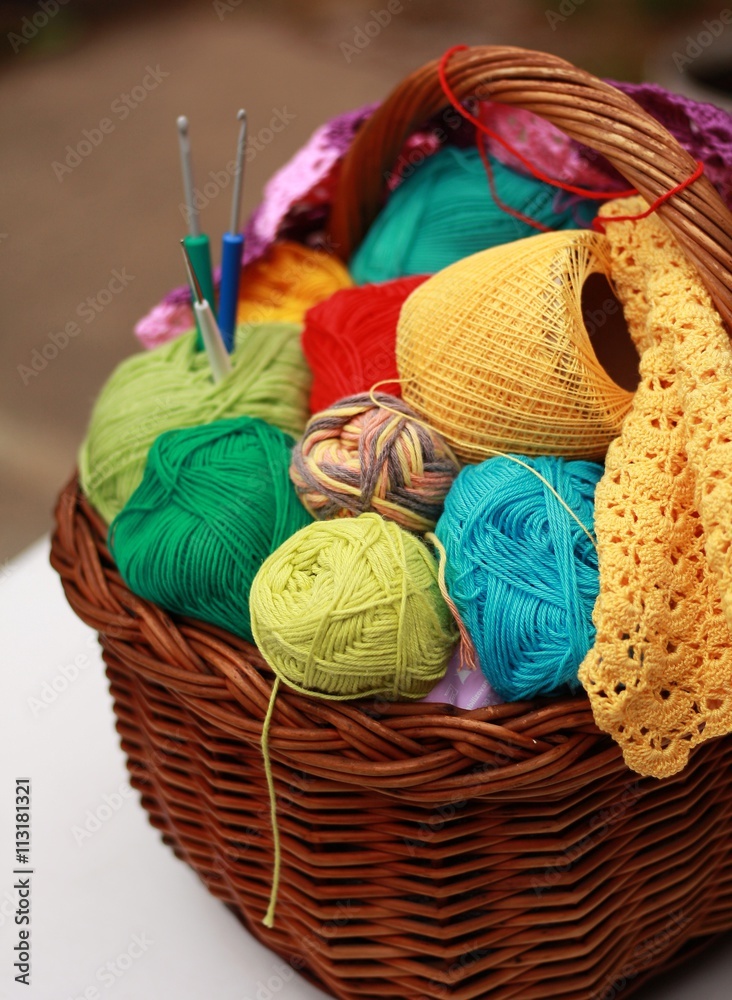 Basket with colorful balls of yarn and hooks
