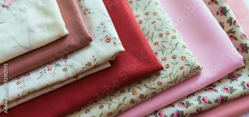 stash of fabric in pastel pinks for sewing projects 
