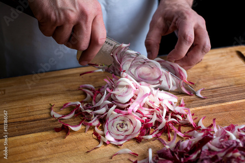 Person chopping endive with knife photo