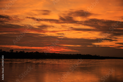 Sun and clouds over river © photonewman
