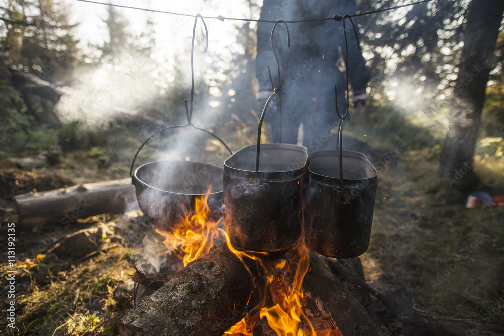 Cooking pans hanging above campfire Cooking pans hanging above campfire