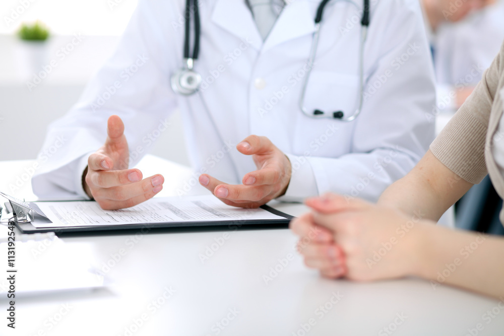 Doctor and patient are discussing something, just hands at the table Doctor and patient are discussing something, just hands at the table