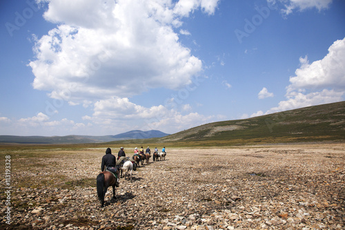 Horseback riders traveling through plain