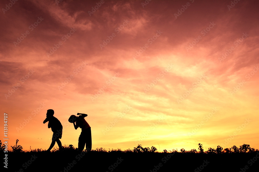 Silhouette children playing at sunset
