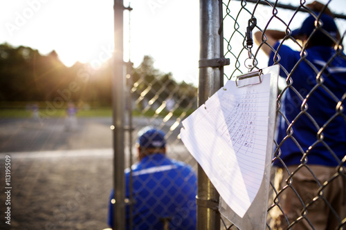 Score card hanging on fence with coach in background photo