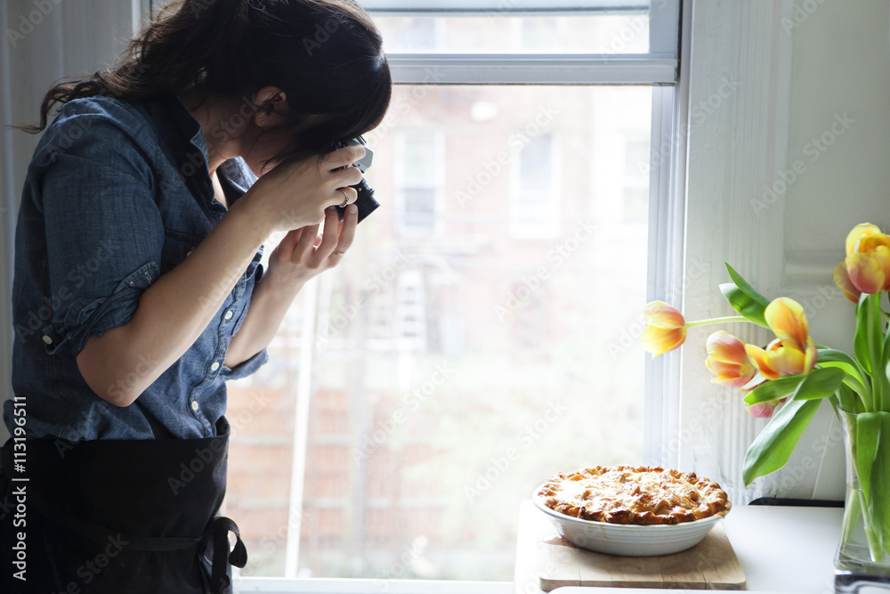 Woman taking picture of baked pie Woman taking picture of baked pie