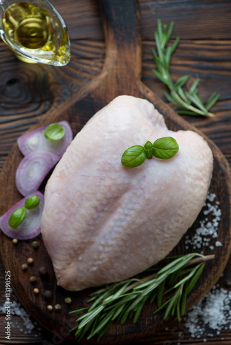 Top view of raw whole chicken breast with cooking ingredients