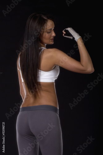 Beautiful long dark hair on fitness dress and gloves on her hands ready for exercise
