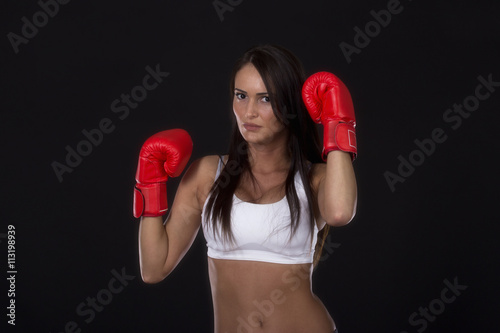 Kick box girl with red gloves on her hands and fitness top ready for training 