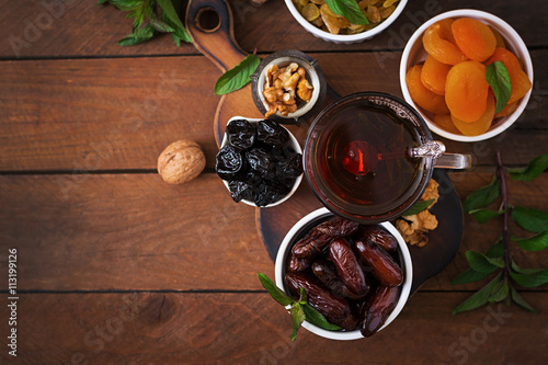 Mix dried fruits (date palm fruits, prunes, dried apricots, raisins) and nuts, and traditional Arabic tea. Ramadan (Ramazan) food. Top view