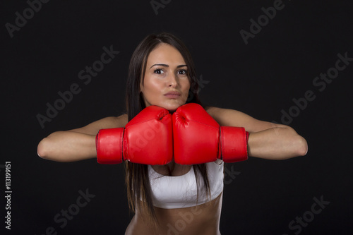 Fitness long dark hair girl with red boxing gloves on her hands