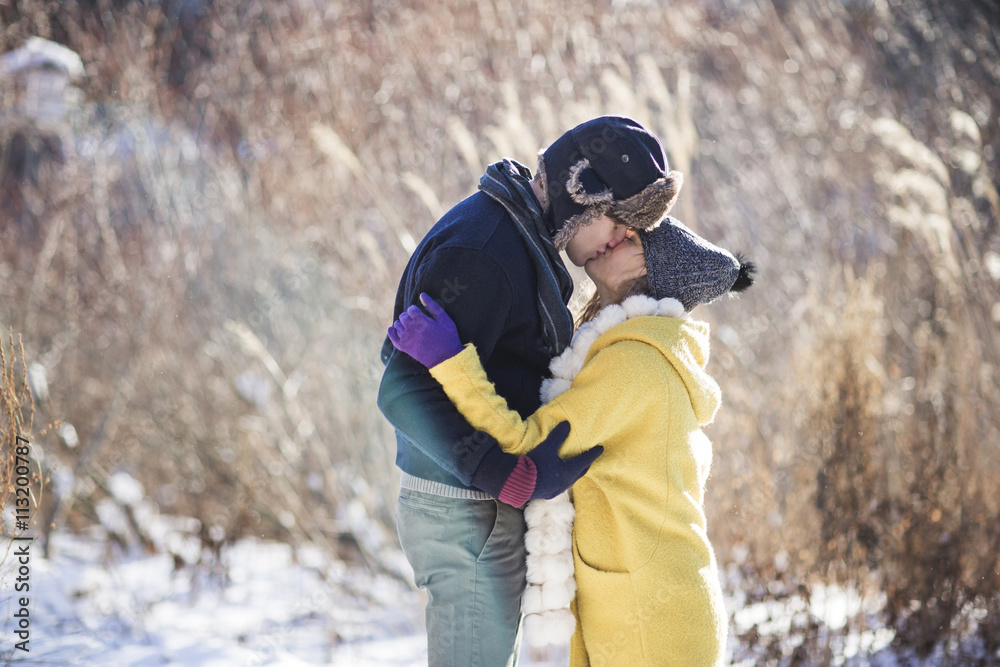 Side view of couple kissing while standing on snow covered field Side view of couple kissing while standing on snow covered field