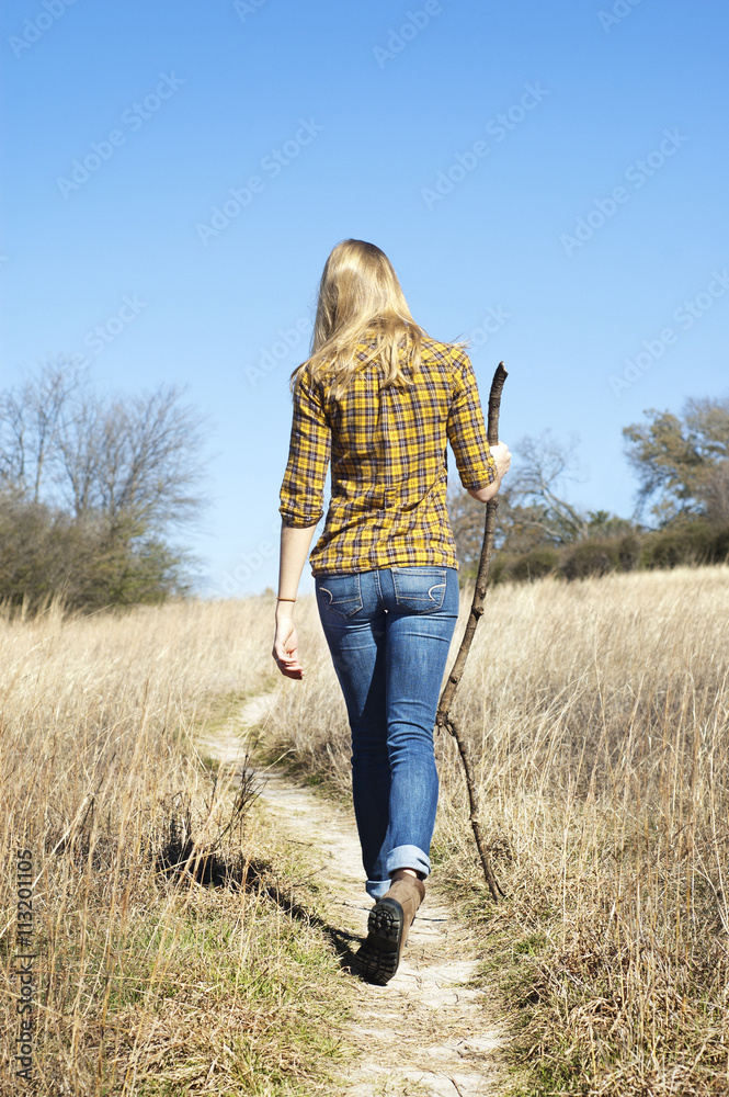 Rear view of woman walking on grassy field against clear sky Rear view of woman walking on grassy field against clear sky