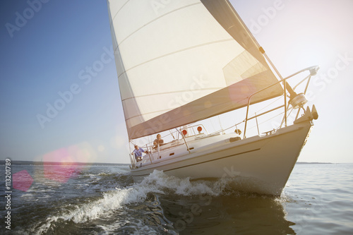 Men sailing on sail boat in sea