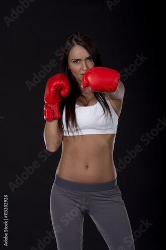 Kick box long dark hair beautiful girl with red gloves on her hands