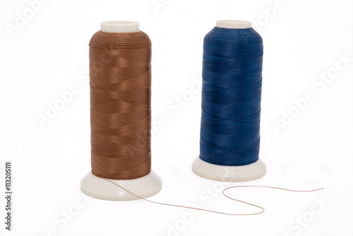 Brown and blue threads on the white isolated background