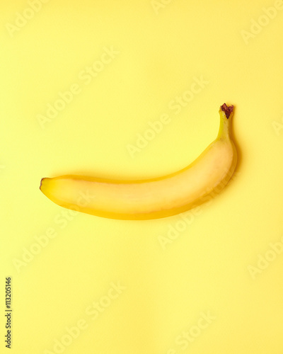 Isolated banana with measuring tape on a yellow background