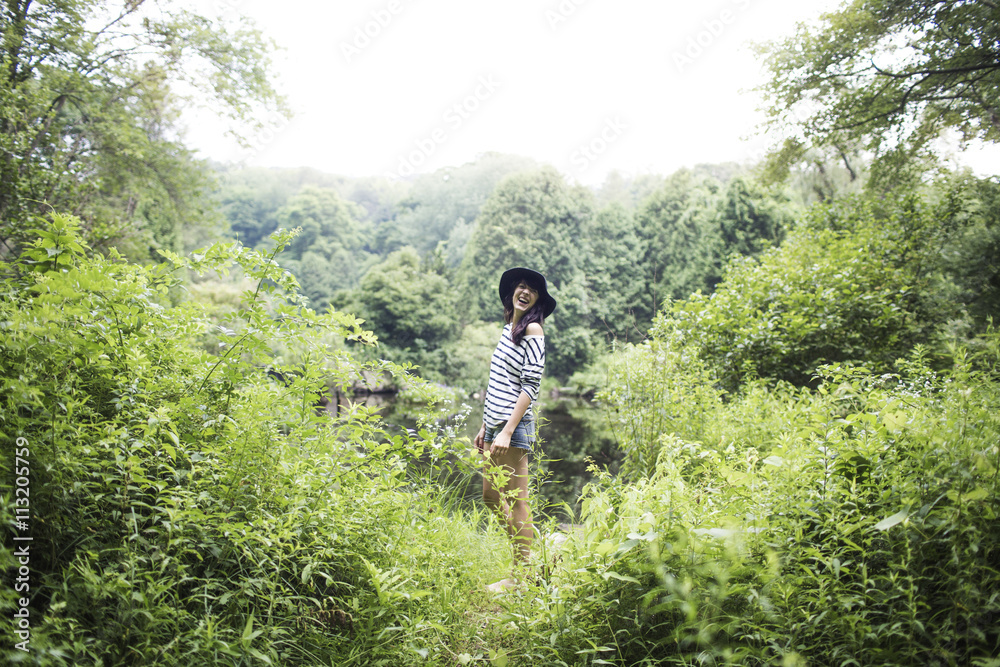 Woman looking away while standing in forest Woman looking away while standing in forest