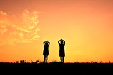 Silhouette children yoga at sky sunset