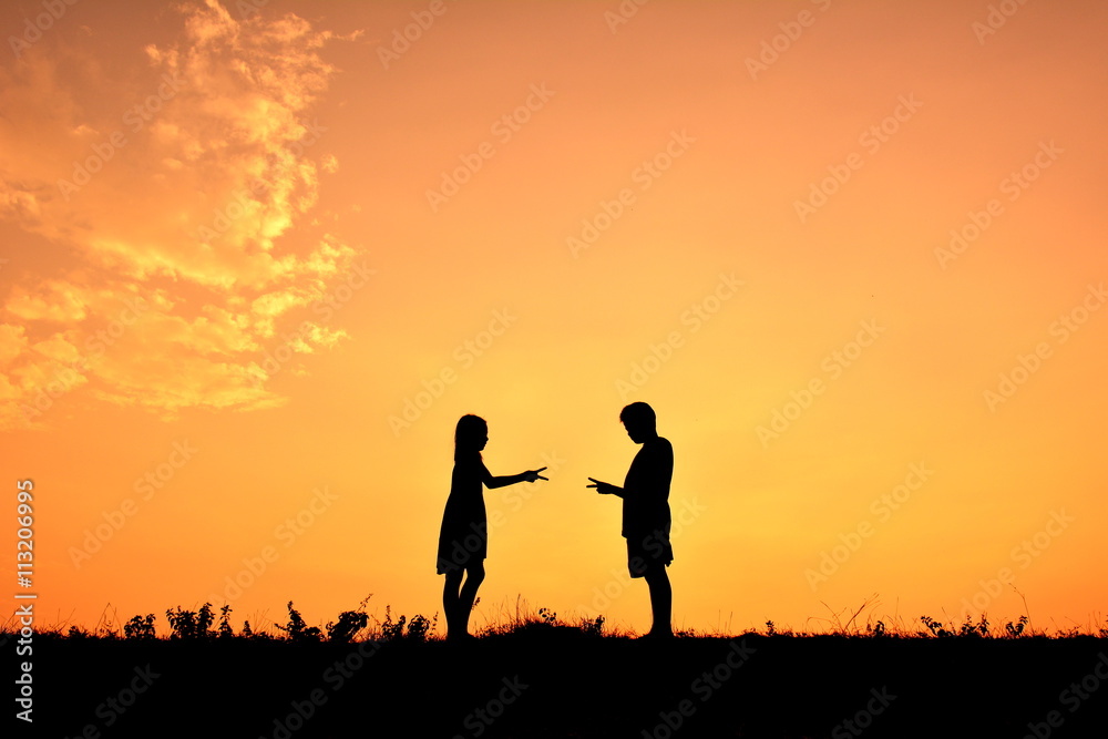 Silhouette children playing rock paper scisors