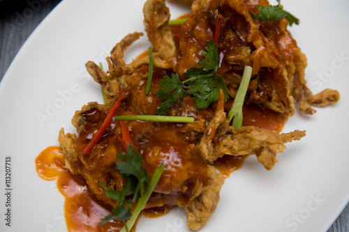 Crispy Soft-Shell Crab with Cilantro and Green Onion. A tantalizing plate of deep-fried soft-shell crab, delicately garnished with vibrant fresh cilantro and slivers of green onion, drizzled with a lu