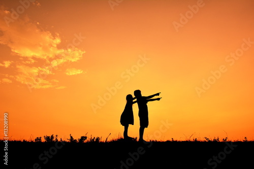 Silhouette children hands up in the sunset.Relax time