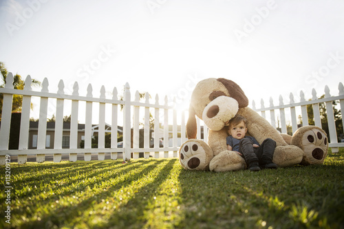 Portrait of cute boy with stuffed toy sitting at backyard