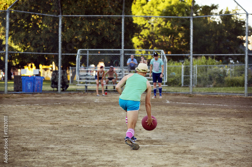 Rear view of man playing dodgeball with friend on pitch photo