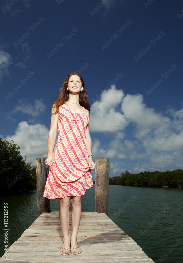 Woman standing on pier against cloudy sky Woman standing on pier against cloudy sky