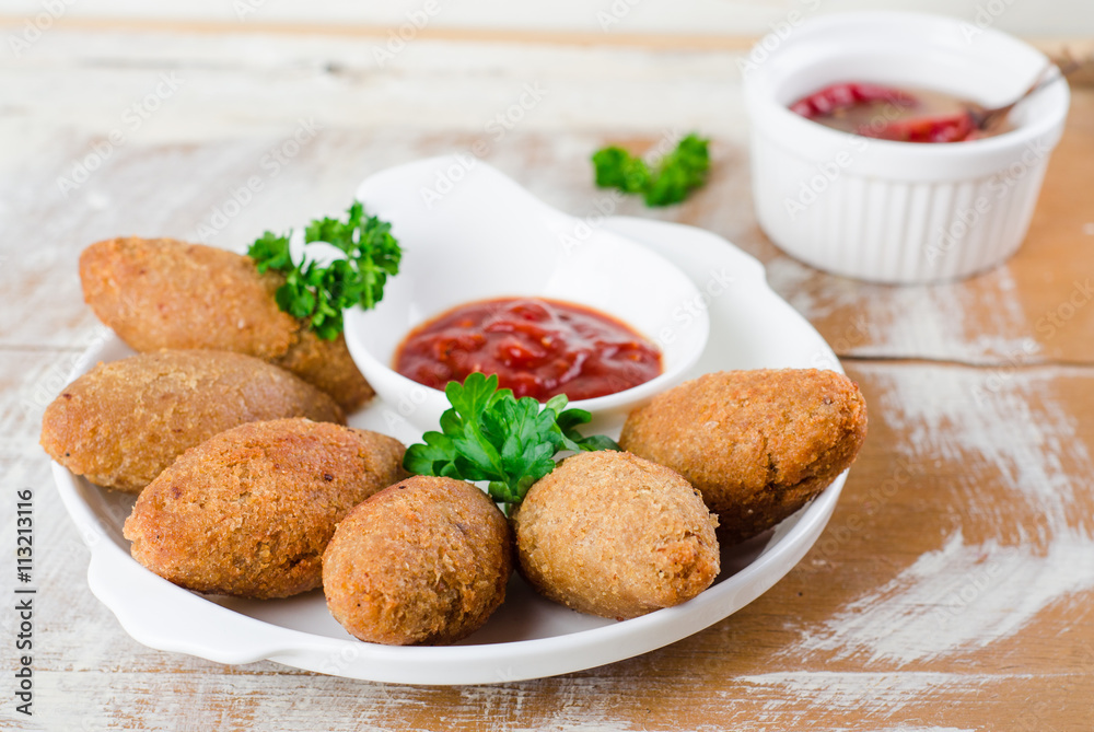 Kibbeh. Traditional Arabian meatballs with parsley in white plate on wooden background. Eastern cuisine. Selective focus Kibbeh. Traditional Arabian meatballs with parsley in white plate on wooden background. Eastern cuisine. Selective focus