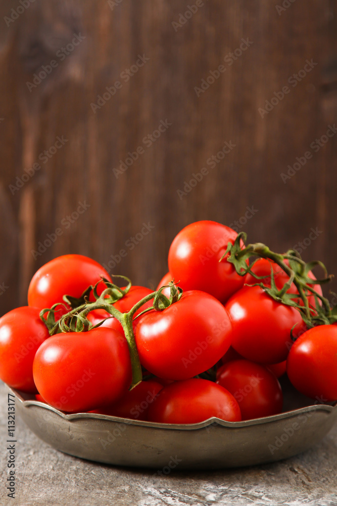 Fresh red tomatoes, isolated on dark background