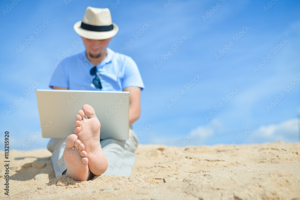 Busy business man working with computer on the beach blue sky background Busy business man working with computer on the beach blue sky background