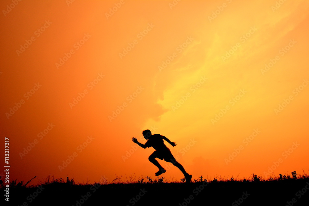 Silhouette a boy running in the sunset