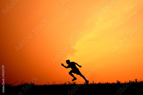 Silhouette a boy running in the sunset
